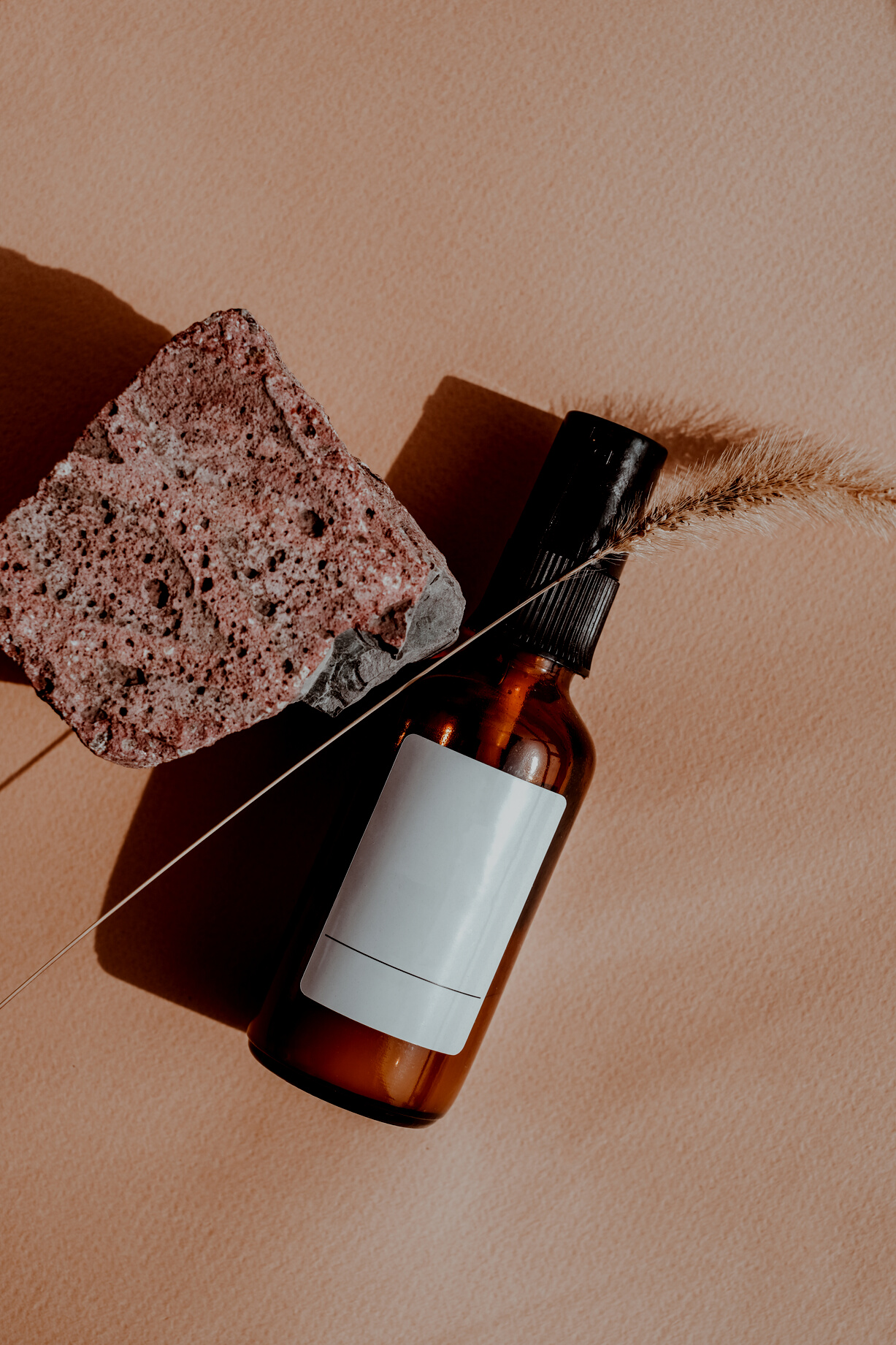 Minimalist Packaging of Spray Bottle with Rock and Grass Flatlay